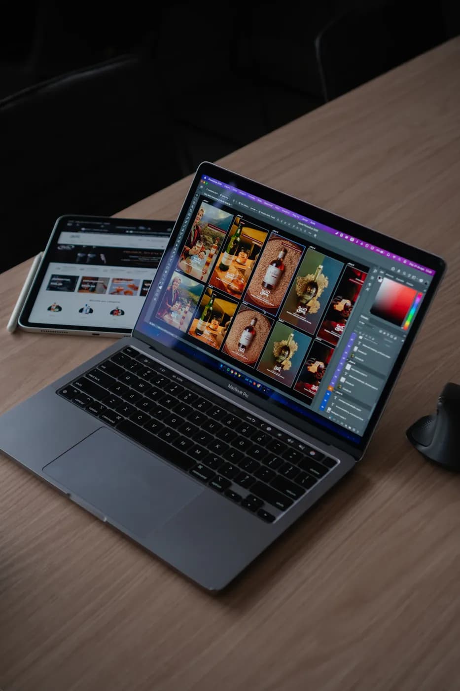 A laptop showing photo thumbnails beside a tablet on a desk