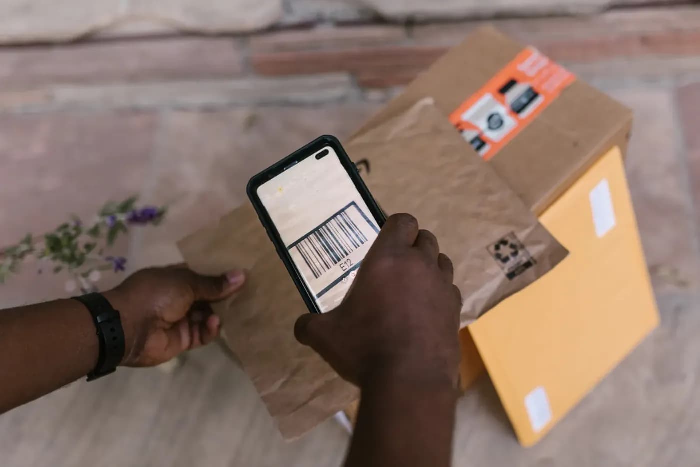 A delivery worker scanning a parcel barcode with a smartphone